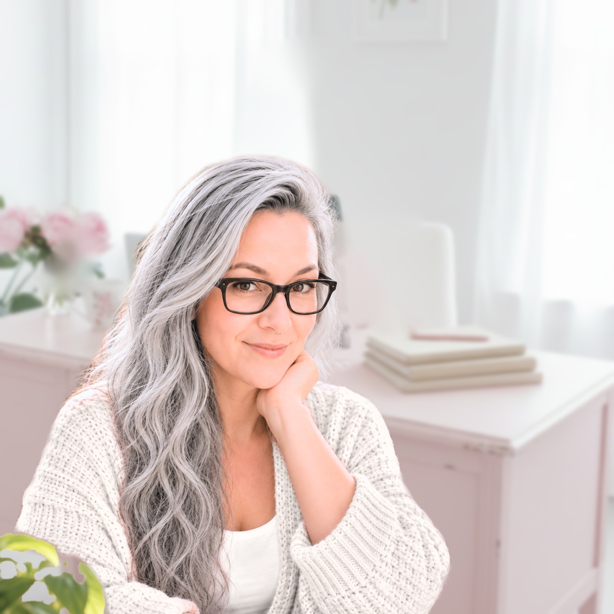 Ina Silver, AI coach for virtual assistants, with long silver hair, smiling in her bright home office